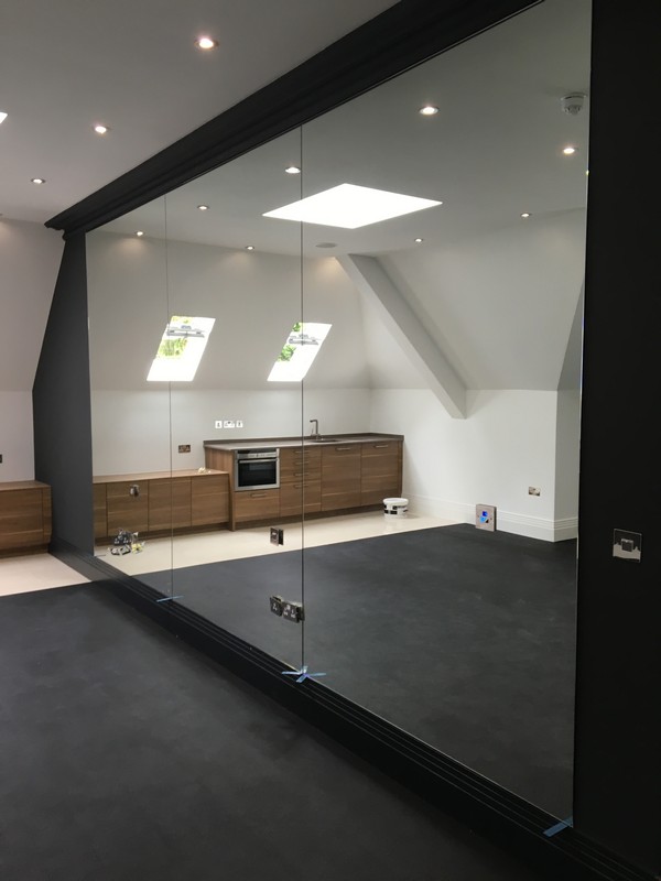 Frameless glass partition in loft conversion by Highgate glaziers