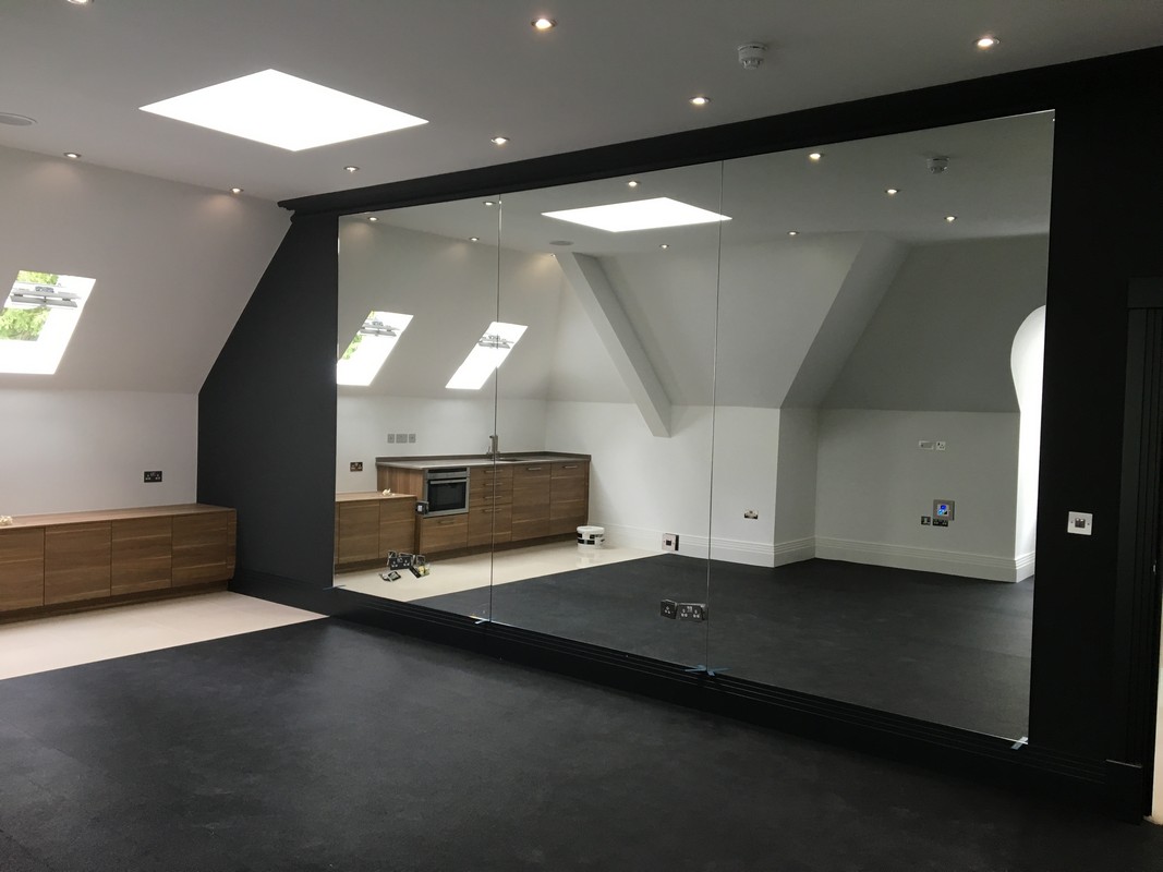 Frameless glass wall dividing loft conversion in Highgate